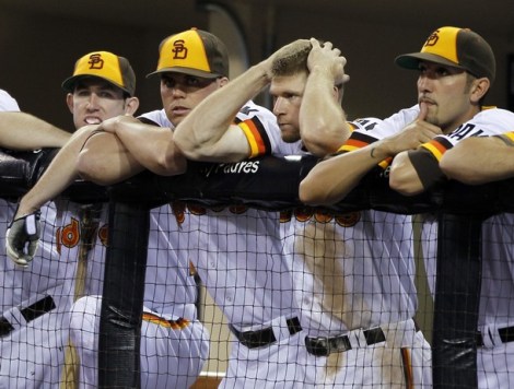 San Diego Padres third baseman Chase Headley holds his head as he hands at the dugout fence as he stands with teammates in the ninth inning during a loss to the Chicago Cubs in their MLB National League baseball game in San Diego